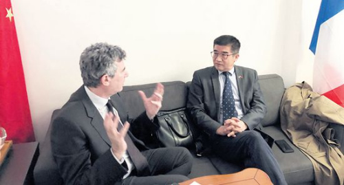 　　正在和客人商討前往中國計(jì)劃的周建防(右)。(《歐洲時(shí)報(bào)》/黃冠杰 攝)