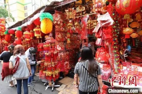 圖為顧客在選購春節(jié)喜慶裝飾品?！×钟纻?攝