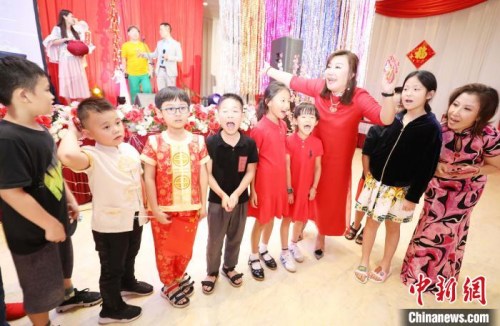 圖為晚會發(fā)起人和組織者王敏筠(右三)和張立霞(右一)給參加晚會的數(shù)十位小朋友發(fā)“壓歲”紅包?！×钟纻?攝