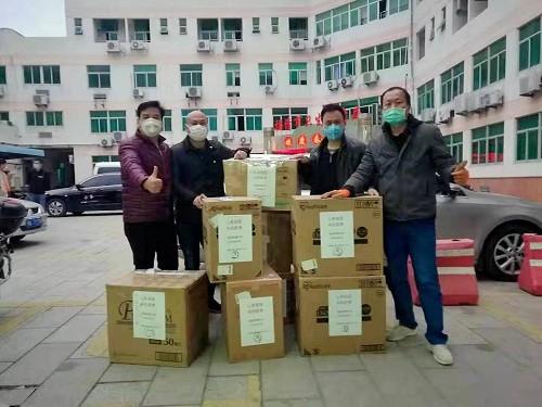 福清華僑中學(xué)日本校友會捐贈的的防疫物資由福清市紅十字會交到福清華僑中學(xué)老師手上。(福清華僑中學(xué)供圖) 