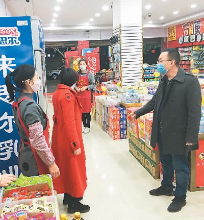 圖為楊姚春（右）在云南省保山市龍陵縣勐糯鎮(zhèn)的一家超市了解商品庫存情況。（李志鋒攝）