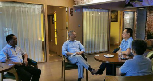 ?？谑袃S聯(lián)主席陳文培(中)與日本海南總商會會長符明潮(左)交流僑企復(fù)工有關(guān)情況。(陳德壯 攝)