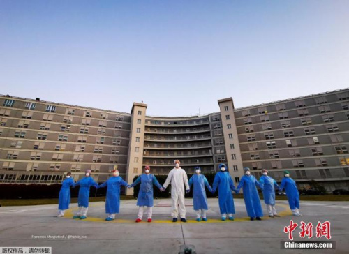 當(dāng)?shù)貢r(shí)間4月6日，意大利克雷莫納一家醫(yī)院的醫(yī)務(wù)人員手牽手，向在新冠肺炎疫情中受影響的人們表示支持和致意。