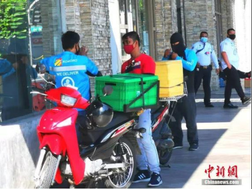 資料圖：4月4日，馬尼拉CBD馬卡蒂綠帶公寓外送快遞的小哥。<a target='_blank' >中新社</a>記者 關(guān)向東 攝