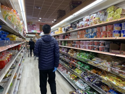 部份連鎖超市暫時(shí)關(guān)閉期仍開放外送服務(wù)，圖為超市業(yè)者手持訂單，為顧客選購商品。(美國《世界日報(bào)》/賴蕙榆 攝)