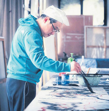 　蔣山青在創(chuàng)作畫作。