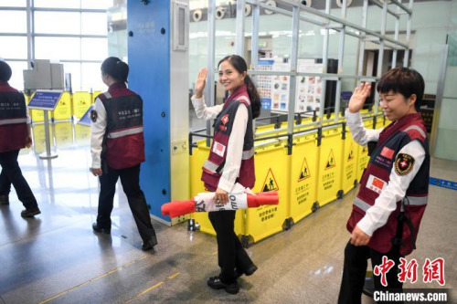 醫(yī)療專家向送行人員走揮手告別。　楊華峰 攝