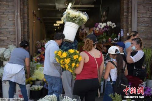美國多地商店恢復(fù)營業(yè)，花市生意紅火。當(dāng)?shù)貢r間5月8日，美國加利福尼亞州洛杉磯市，當(dāng)?shù)夭糠稚虡I(yè)開始恢復(fù)營業(yè)，人們在洛杉磯花區(qū)購物。
