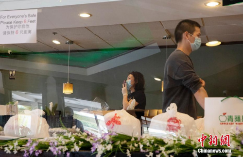 遼寧人汪女士與合伙人5年前在這里開(kāi)了“青蘋(píng)果”餐館。她坦言，現(xiàn)在餐館的狀態(tài)就是“生存，能挺下來(lái)就行”。圖為汪女士用微信與客戶(hù)交流。<a target='_blank' >中新社</a>記者 劉關(guān)關(guān) 攝