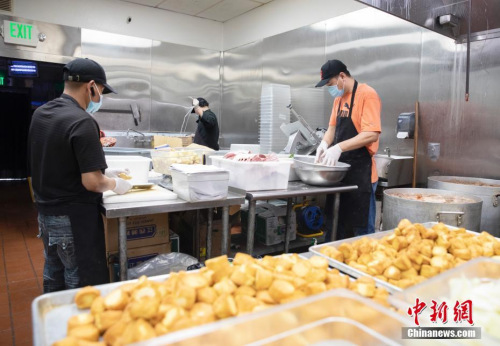 廚師們忙著制作各自負(fù)責(zé)的食品。<a target='_blank' >中新社</a>記者 劉關(guān)關(guān) 攝