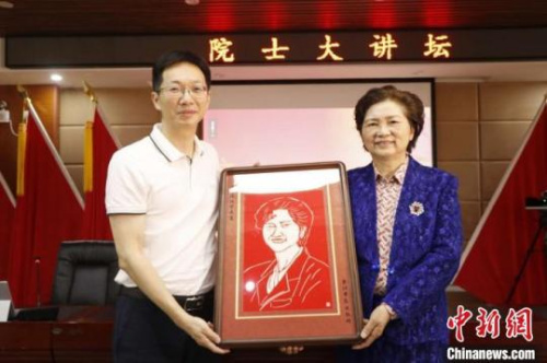 　圖為晉江市衛(wèi)健局黨組副書記、市醫(yī)院院長陳銘向李蘭娟院士贈送剪紙作品?！∨ＰФY　攝