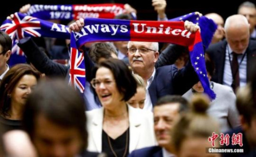 　資料圖：當(dāng)?shù)貢r(shí)間1月29日，歐洲議會(huì)批準(zhǔn)“脫歐”協(xié)議。圖為投票結(jié)束后，在場(chǎng)議員高舉“永遠(yuǎn)團(tuán)結(jié)”旗幟。<a target='_blank' >中新社</a>發(fā) 歐盟供圖