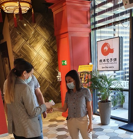 “九澤烤鴨”專設(shè)服務(wù)員給進(jìn)店顧客測量體溫。(“哈薩克斯坦新觀察”微信公眾號(hào))