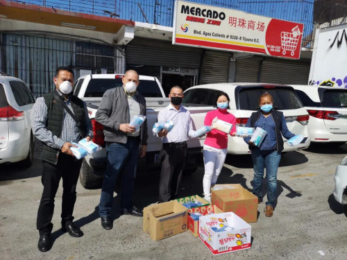 圖為梁綺梅代表超市向當(dāng)?shù)卣偷谝痪€工作人員捐贈醫(yī)療物資。受訪者供圖。