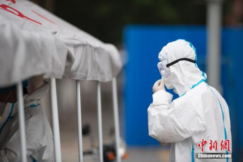 資料圖：北京市豐臺區(qū)西山甲一號小區(qū)新冠肺炎核酸檢測采樣點，一名負責采樣的醫(yī)護人員穿戴好防護裝備走向采樣區(qū)。