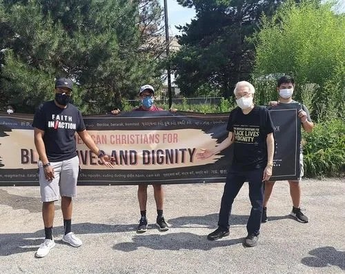 華人和黑人在同一條橫幅標(biāo)語(yǔ)前合影。(《芝加哥華語(yǔ)論壇》 張大衛(wèi) 攝)