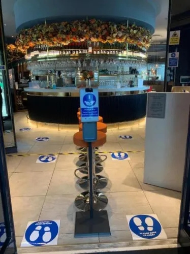 快樂小羊在門口設(shè)置了獨(dú)立免接觸的感應(yīng)式洗手液，并貼了地貼進(jìn)行引流。(受訪者提供)