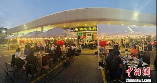 加拿大時間7月18日晚上，大多倫多地區(qū)華人聚居區(qū)萬錦市，一家中餐館開起了露天大排檔，不僅有燒烤啤酒，還有樂隊駐場演出。<a target='_blank' >中新社</a>記者 余瑞冬 攝