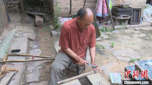 圖為秦森林正在釘蜂箱?！?jiān)?攝