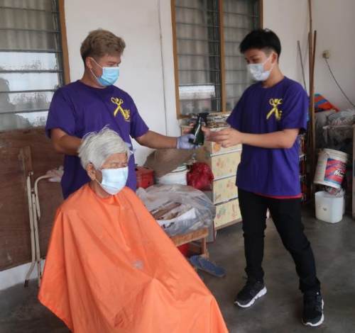 寇金來為社區(qū)長者免費(fèi)剪發(fā)。（馬來西亞《星洲日報(bào)》）