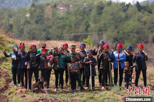 布哈與村名們一同種植果樹時合影。圖片由武警部隊提供