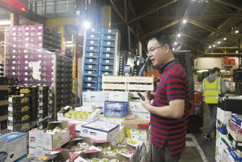 熊鵬在市場(chǎng)跟老板詢價(jià)。（《歐洲時(shí)報(bào)》/田皓雪子 攝）