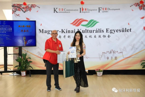 匈中文化交流協(xié)會會長滕維杰（左）為成人組一等獎獲得者李嘉欣頒獎。（匈牙利《新導(dǎo)報》）