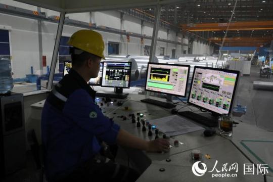 鼎力新材料公司的工廠投資1.2億美元，每年可以生產(chǎn)規(guī)格從5mic—2mm的鋁箔共計8萬噸。圖為技術(shù)員在操作切割鋁箔的軋機。人民網(wǎng)記者孫廣勇攝
