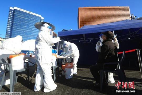 資料圖：2020年12月14日，韓國(guó)首爾，醫(yī)務(wù)人員對(duì)市民進(jìn)行新冠病毒檢測(cè)。