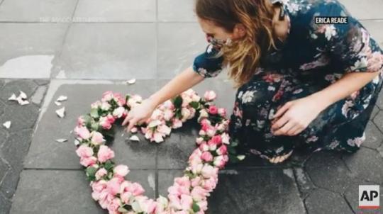 美國藝術(shù)家莉比在紐約放置花朵展品。圖片來源：美聯(lián)社新聞視頻截圖。