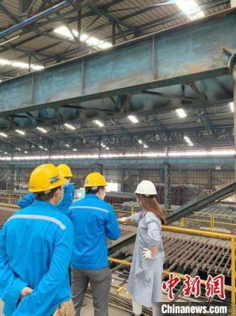 圖為羅小穎(右一)查看鋼材廠。羅小穎 供圖