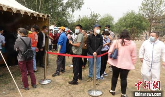 在現(xiàn)場排隊等候接種疫苗的人們?！』蕰员?攝