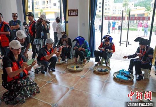 海外華媒代表在彝繡工坊與繡娘溝通交流?！⊥趵?攝