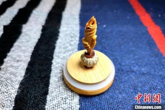 圖為黃樹立創(chuàng)作的核雕“火炬”?！∶疯O瀧 攝