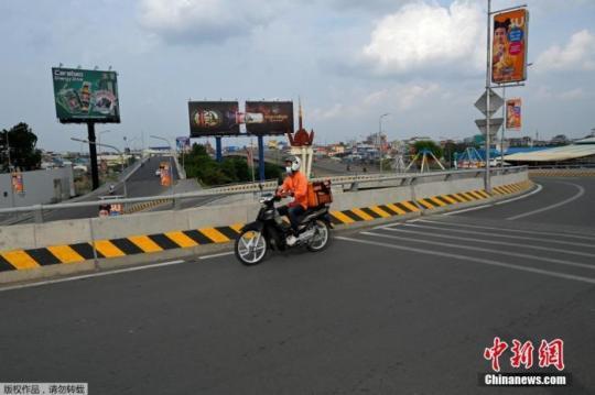 當(dāng)?shù)貢r間4月16日，柬埔寨金邊，一名食品配送員在空蕩蕩的馬路上行駛。柬埔寨政府14日晚宣布，首都金邊和干拉省大金歐市從4月15日零時起“封城”14天，直至4月28日。除“重要服務(wù)”領(lǐng)域，任何人不得隨意外出。