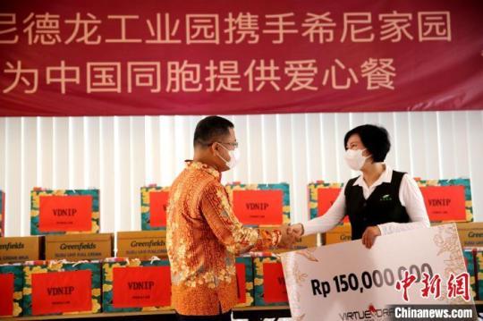 圖為徐捷向希尼家園負(fù)責(zé)人佟桐女士提供愛心支票。　印尼德龍工業(yè)園 供圖