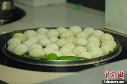 制作好的清明粑放在葉子上，并放在鍋里蒸熟?！±铤Q 攝