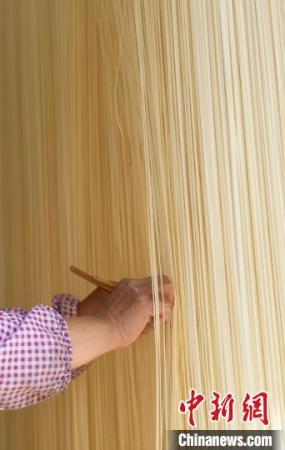 村民用面筷輕輕撥開爽面，避免粘連?！⊥鮿?攝