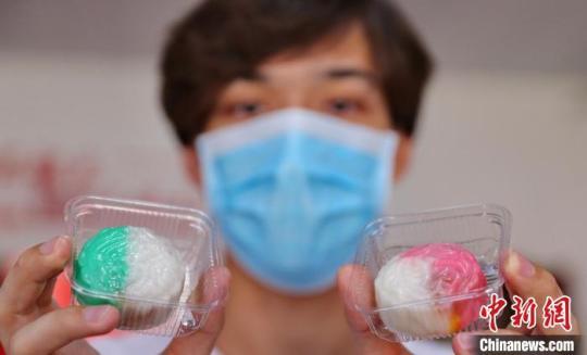 圖為外國(guó)留學(xué)生展示制作完成的月餅?！〔芙ㄐ?攝