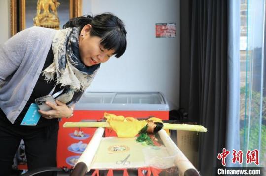 一位海外華媒代表在一家博物館觀看尚未完成的蜀繡作品?！⊥趵?攝