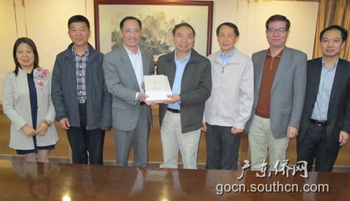 中國僑網(wǎng)林琳副主任(右四)向陳安副主任(左三)贈送《廣東華僑史》編撰成果