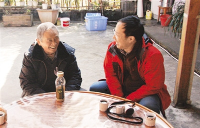 中國僑網(wǎng)記者正在采訪張文才(左)