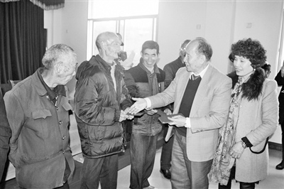 中國(guó)僑網(wǎng)圖為唐濤甫伉儷向當(dāng)?shù)毓畔±先速?zèng)送拜年紅包。(林潞 攝)