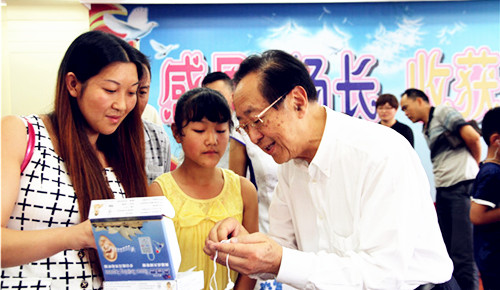 魏基成先生親自為聽障兒童驗(yàn)配助聽器。