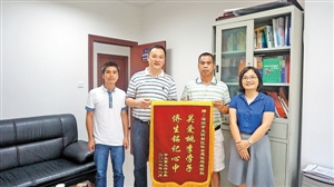 僑民黃家儀代表全家向新區(qū)社建局統(tǒng)僑科送錦旗致謝。