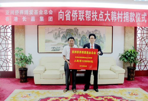 亞洲僑界博愛基金總會創(chuàng)會會長、香港金龍科技集團(tuán)有限公司董事局主席胡國贊(右)向大韓村捐贈