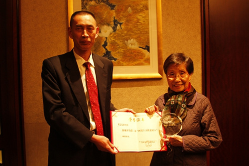 何光先(左)向嚴(yán)崔秀瓊轉(zhuǎn)發(fā)“2016年度四川省十大扶貧好人”獲獎證書