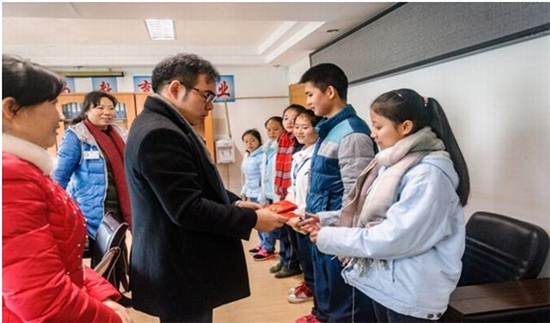 中國(guó)僑網(wǎng)圖為趙興先生為學(xué)生發(fā)放助學(xué)金