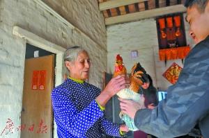 中國(guó)僑網(wǎng)廣州日?qǐng)?bào)記者向雞美英贈(zèng)送《金雞報(bào)喜》。廣州日?qǐng)?bào)記者何波攝