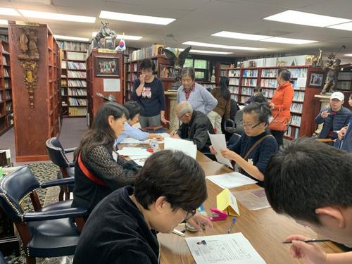 中國僑網(wǎng)圖為義工們在幫忙申請者整理資料。 (美國《世界日報》 王政賢/攝)